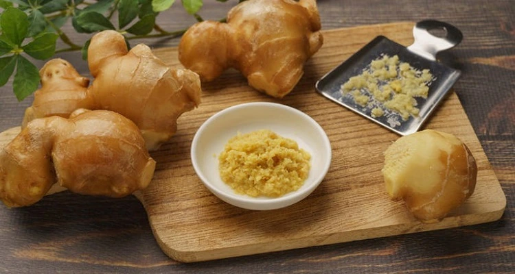 Your Natural Health - Freshly grated ginger being added to a dish.