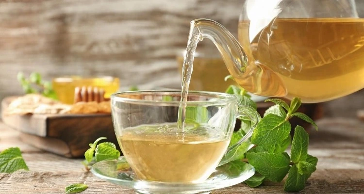 Your Natural Health - A cup of lemon balm tea with fresh lemon balm leaves and a tranquil setting.